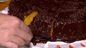 cortando-o-bolo-de-cenoura-com-cobertura-de-chocolate